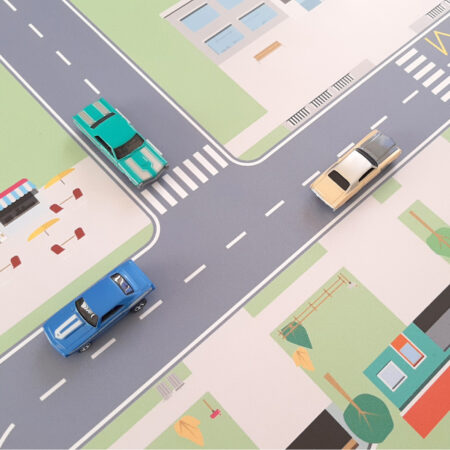 Un tapis de jeu avec un circuit de course pour jouer aux petites voitures que les enfants adorent